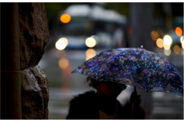 Life on Main St - Mike Redd & Lynn Smith - Photo of person ins treet with umbrella - Tap Gallery